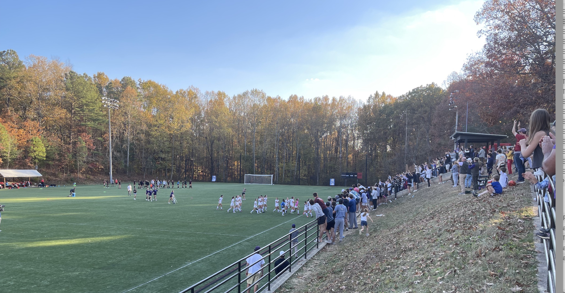 Sewanee Tigers soccer match with fans lining the hillside amid fall foliage at Puett Field